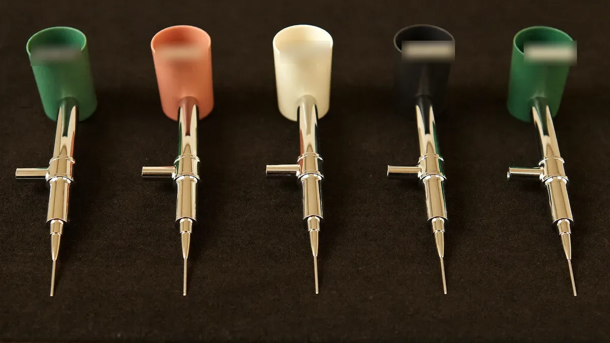 Row of airbrushes on a stand in a workshop